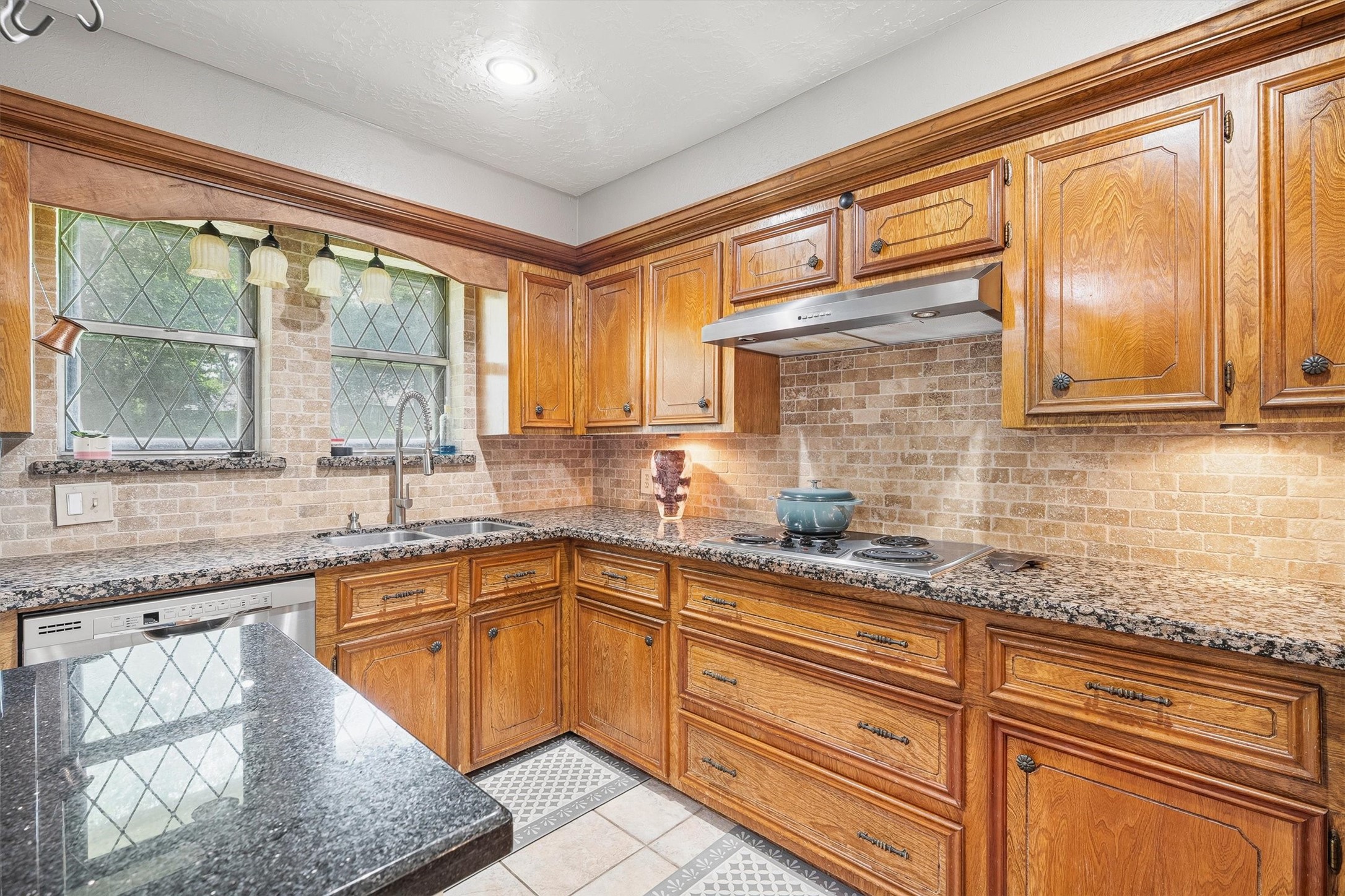826 North Rivershire Drive Conroe, TX 77304 - Photo 14 of 46 The details tell the story here. Leaded glass window, granite countertops, under-cabinet lighting, and warm textured walls that make this kitchen feel like it was designed with intention from top to bottom.