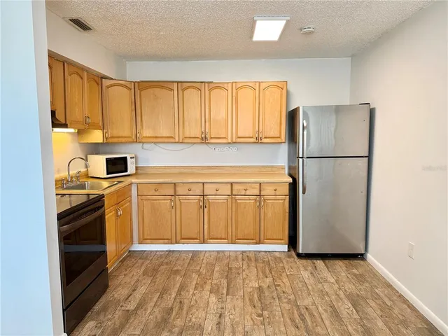 a kitchen with granite countertop cabinets stainless steel appliances and a sink