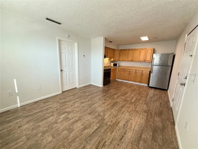 a kitchen with a refrigerator and a stove top oven
