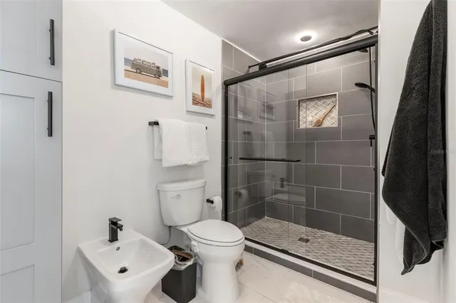 a bedroom with a bed a chandelier and a couch