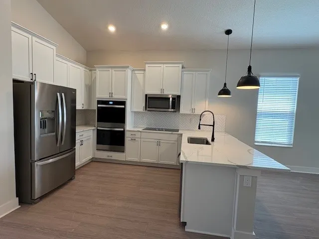 a kitchen with kitchen island a counter space stainless steel appliances and cabinets
