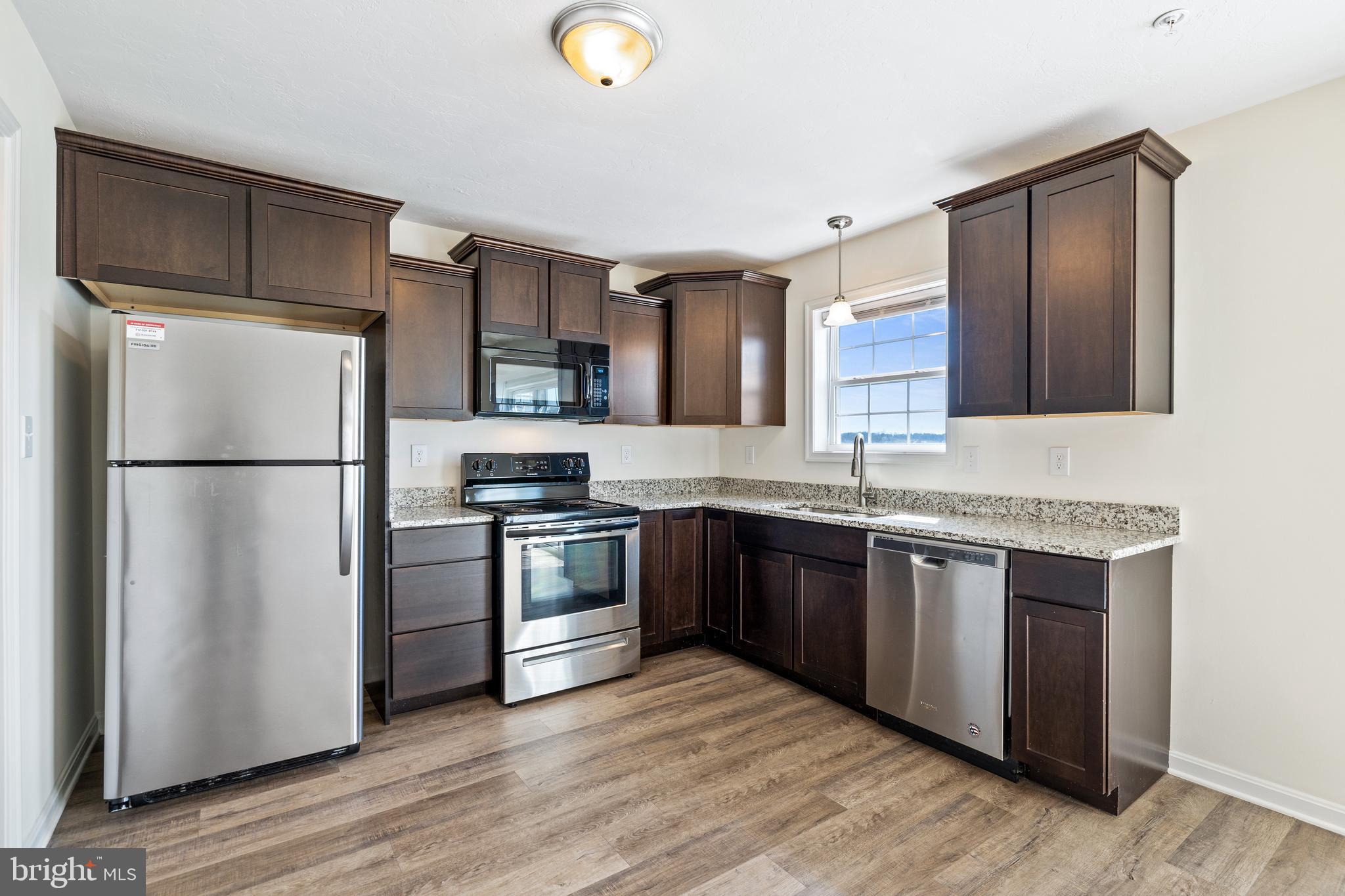 12 Secretariat Drive Hanover, PA 17331 - Photo 4 of 20 a kitchen with stainless steel appliances granite countertop a refrigerator stove a sink and a granite counter tops with wooden floors