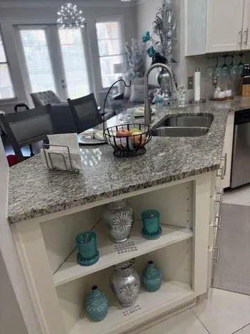 a kitchen with kitchen island granite countertop stainless steel appliances a sink a stove and a counter top space