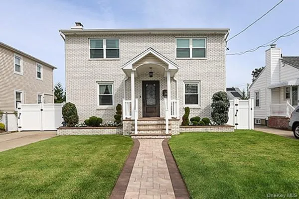 a front view of a house with a garden and yard