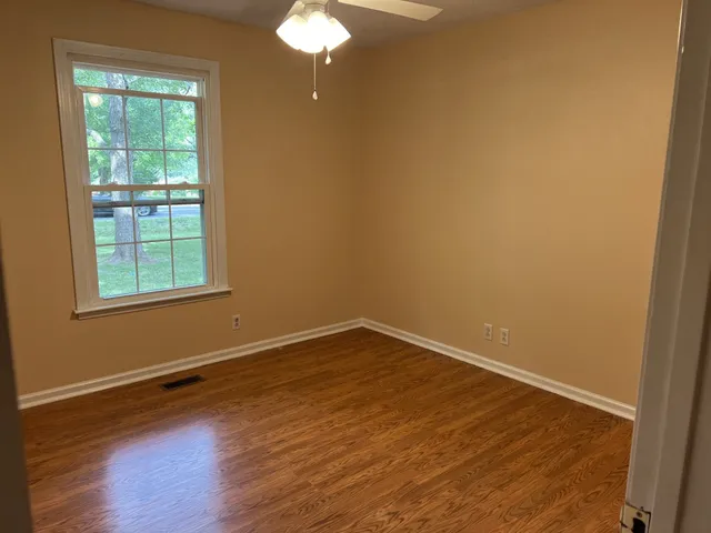 wooden floor in an empty room with a window