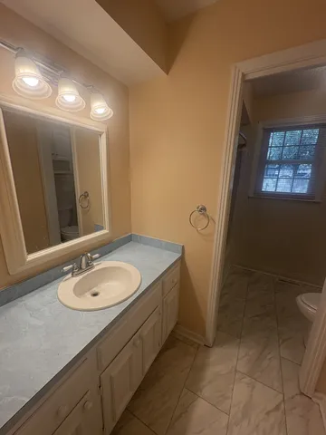 a bathroom with a granite countertop sink and a mirror