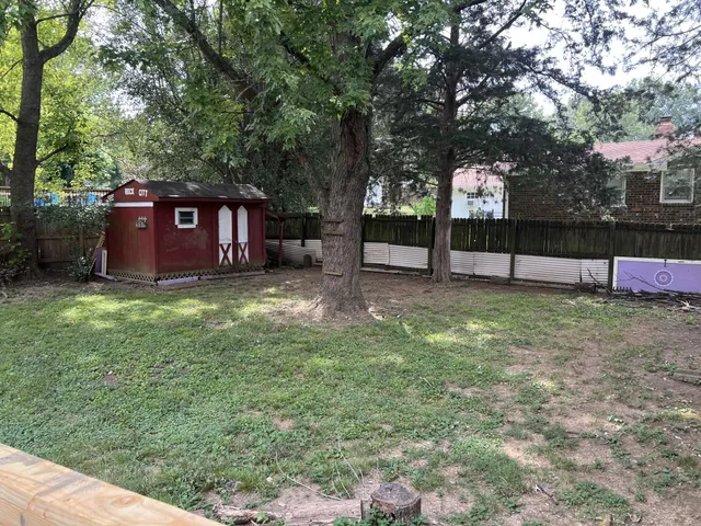 a view of a backyard with large trees