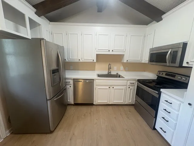 a kitchen with cabinets and stainless steel appliances
