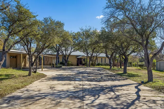 a front view of a house with a yard and trees
