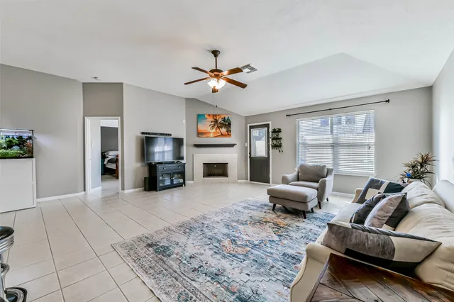 a living room with furniture a flat screen tv and a fireplace