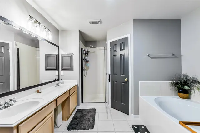 a bathroom with a tub shower and a sink