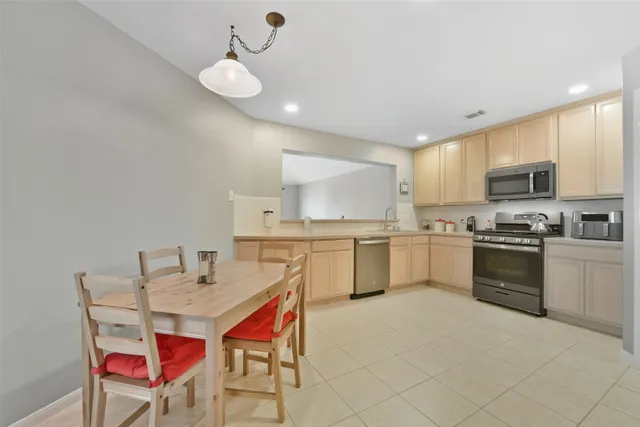 a kitchen with a dining table chairs sink and white cabinets