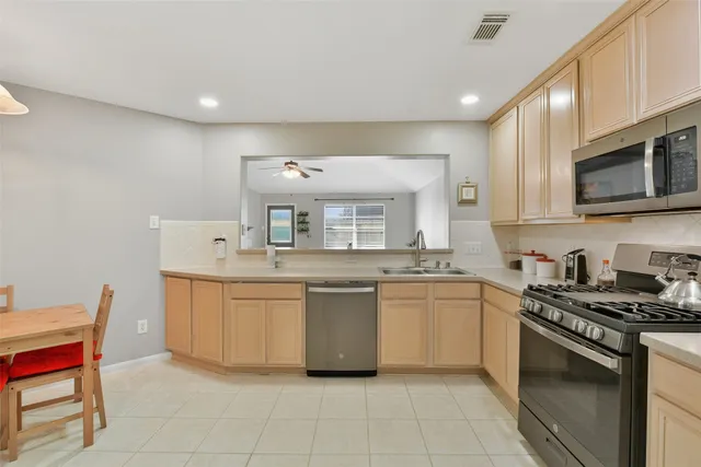 a kitchen with stainless steel appliances granite countertop a sink and stove top oven