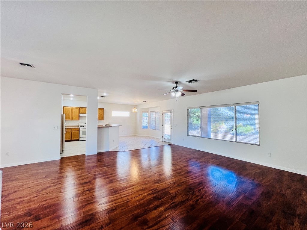 3047 Hickory Valley Road Henderson, NV 89052 - Photo 3 of 33 Refined wood flooring flows through this bright living space, connecting seamlessly to the dining and kitchen areas.