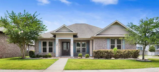 a front view of a house with a yard and trees
