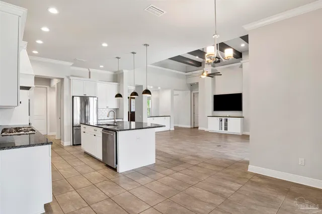 a kitchen with granite countertop a stove a sink and a refrigerator