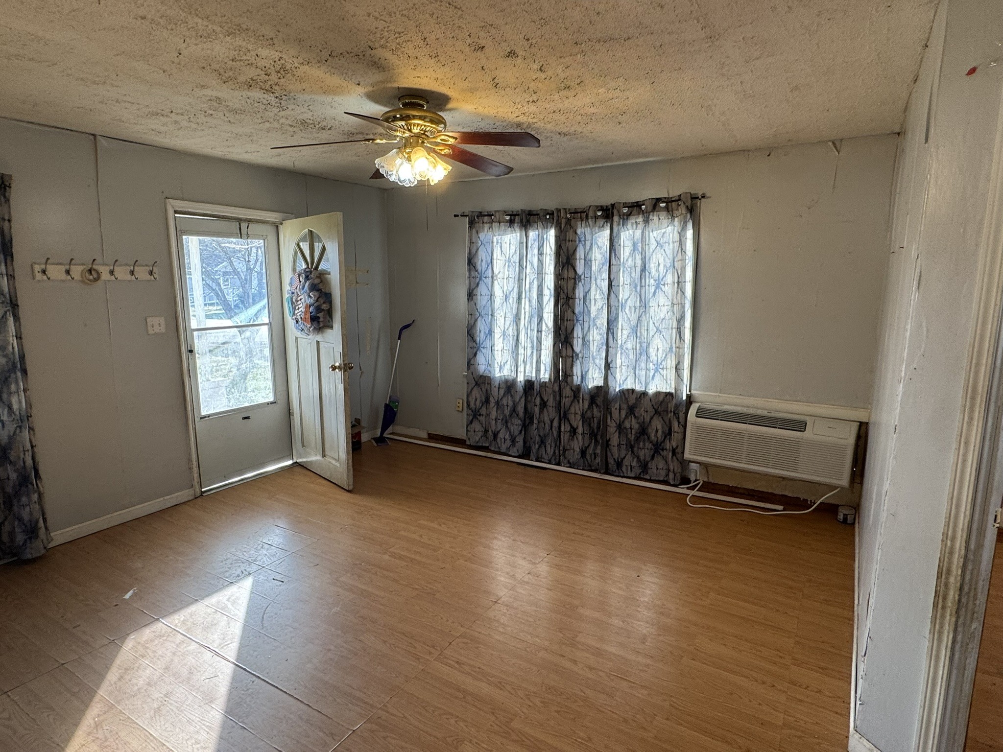 212 College Street North Cowan, TN 37318 - Photo 3 of 11 an empty room with wooden floor fan and windows