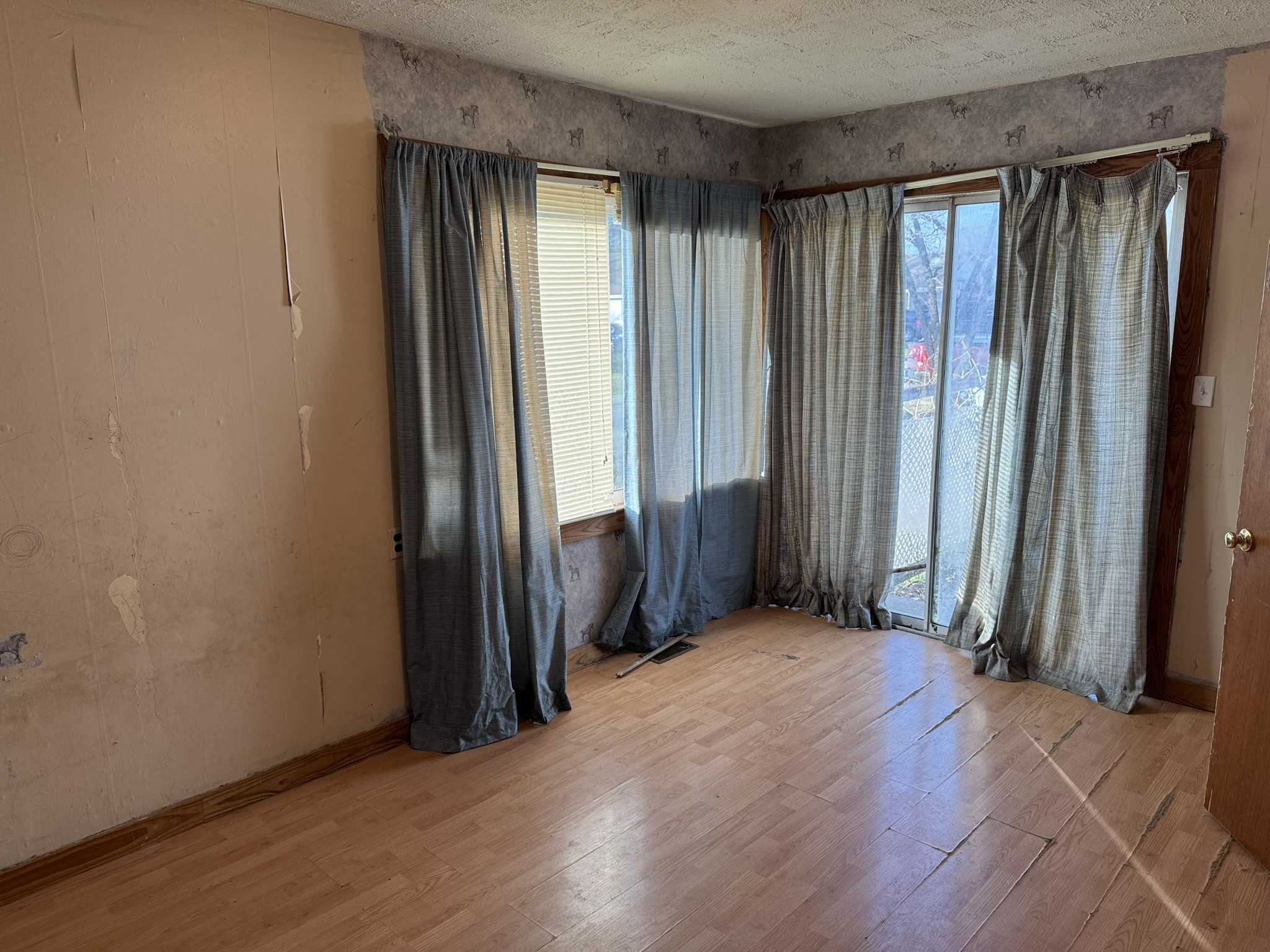 212 College Street North Cowan, TN 37318 - Photo 6 of 11 an empty room with wooden floor and windows with curtains