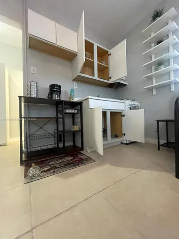 a view of an empty room with a fireplace and a window