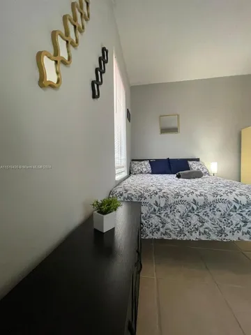 a bedroom with a bed and a potted plant on the table