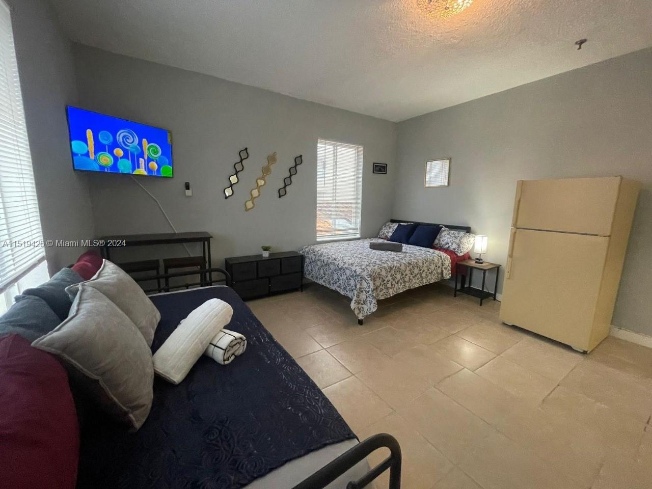 Mid Beach Miami Beach, FL 33140 - Photo 9 of 25 a living room with furniture and a flat screen tv