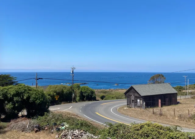 a view of a wooden house with a flower garden