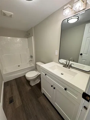 a bathroom with a double vanity sink mirror and toilet