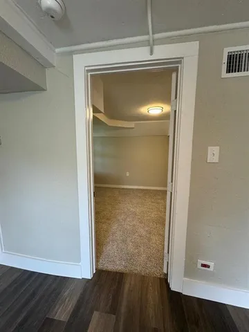 a view of an empty room with wooden floor