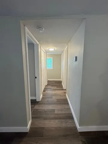 a view of hallway with wooden floor