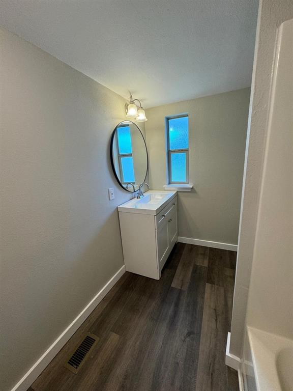 1201 North Rusk Street Weatherford, TX 76086 - Photo 10 of 32 a room with wooden floor and mirror