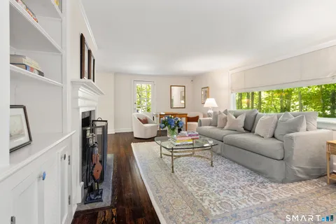 a living room with furniture large window and a flat screen tv