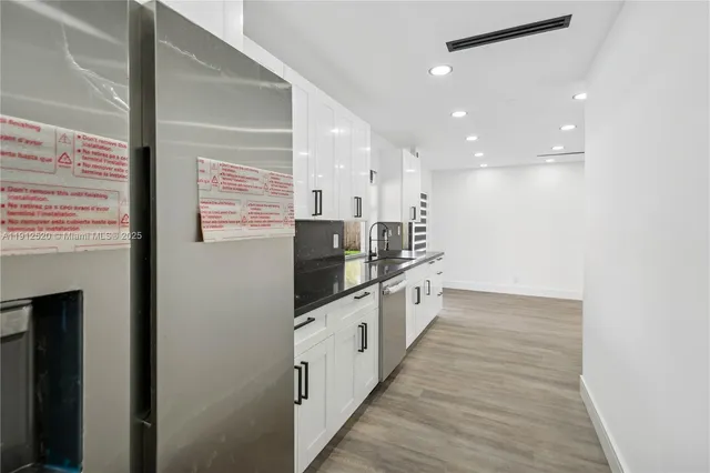 a large kitchen with stainless steel appliances a large counter top