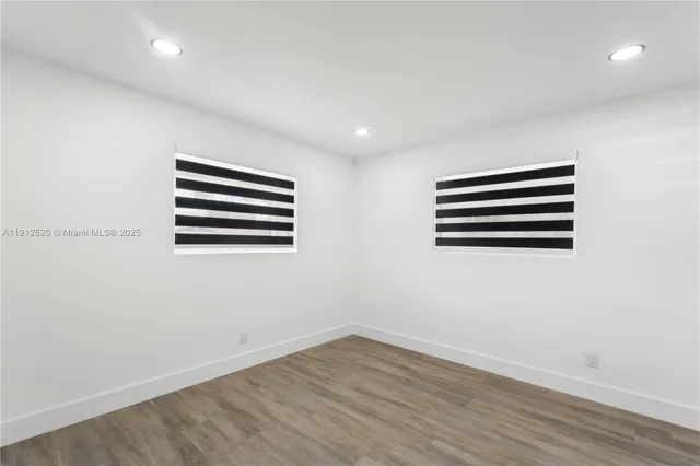 a view of a room with wooden floor and a window