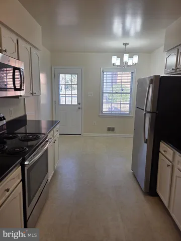 a kitchen with stainless steel appliances granite countertop a refrigerator a stove a sink dishwasher and a refrigerator