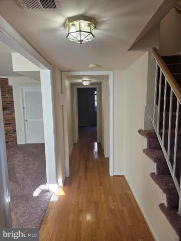 a view of a hallway with wooden floor and staircase