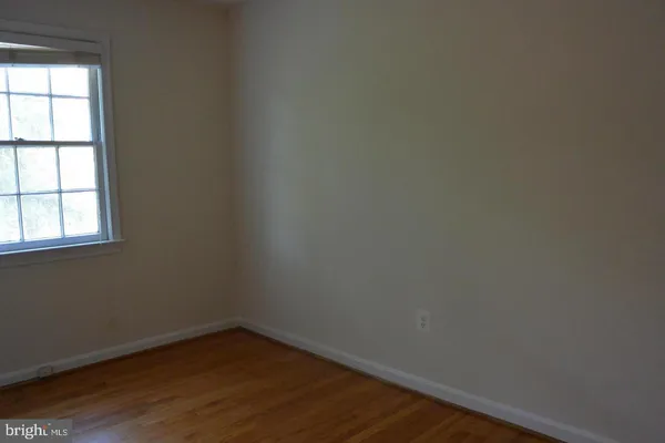 a view of a small space with wooden floor and a window