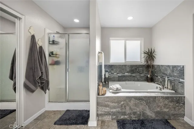 a bathroom with a tub a window and a shower