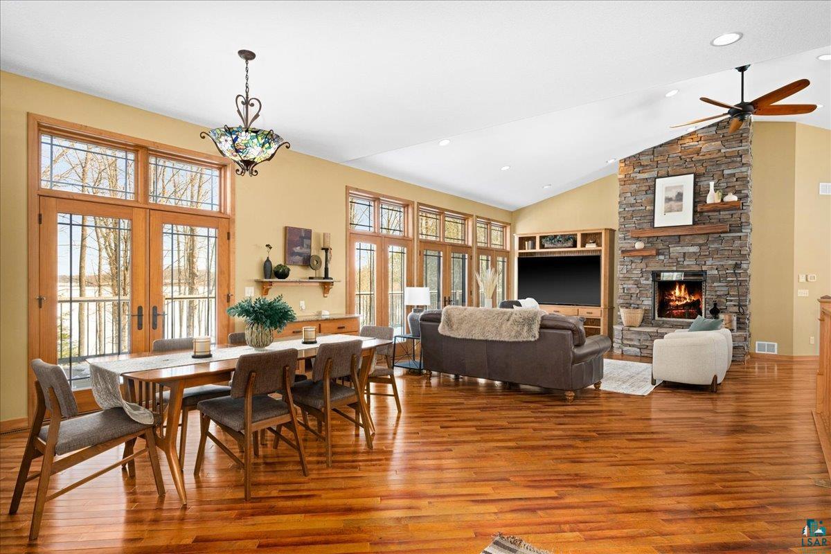 92598 Spells Road Sturgeon Lake, MN 55783 - Photo 6 of 60 Dining room with wood finished floors, lofted ceiling, french doors, a stone fireplace, and ceiling fan
