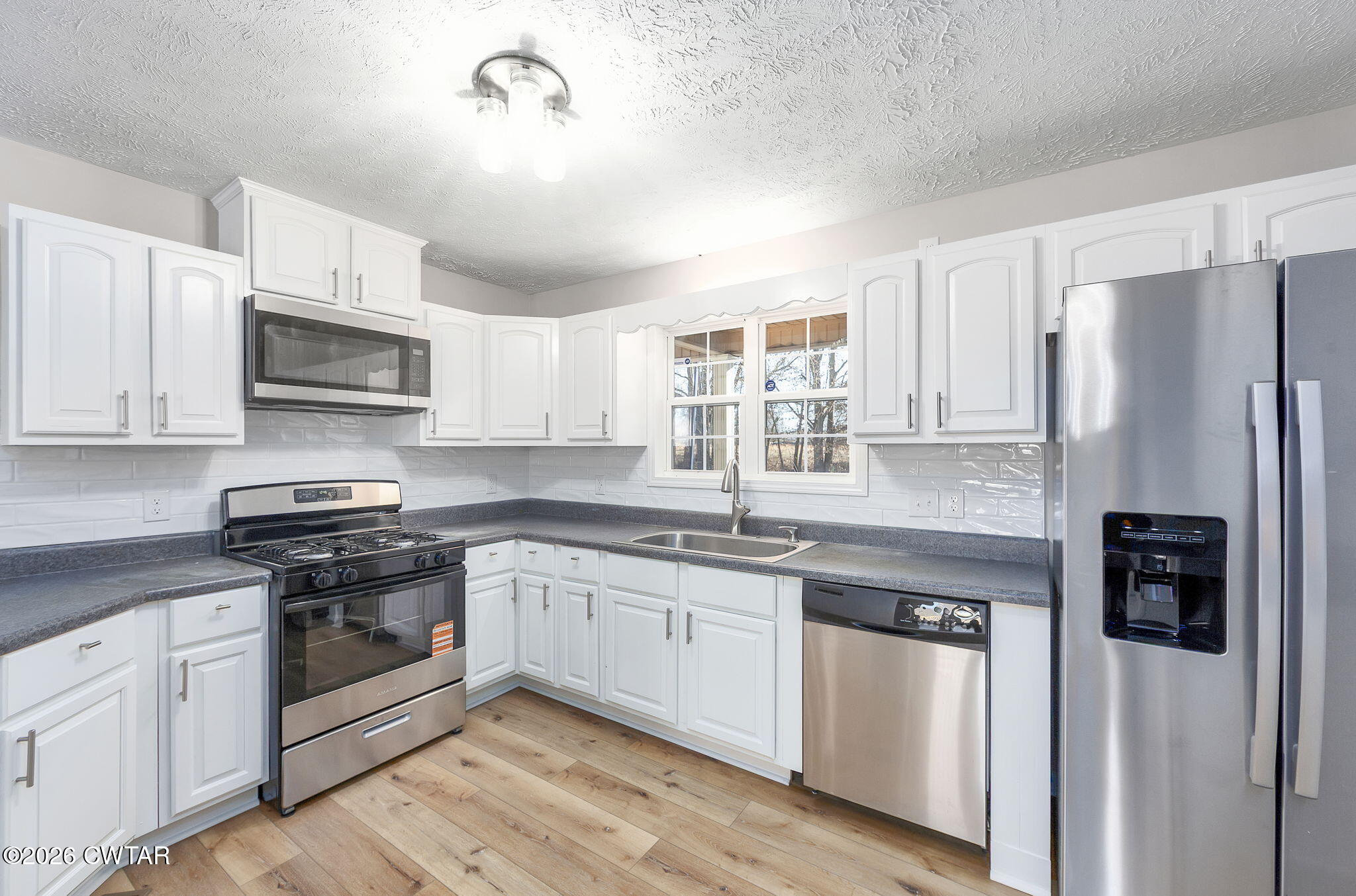 2265 Bond Ferry Road Brownsville, TN 38012 - Photo 15 of 26 a kitchen with stainless steel appliances granite countertop a stove a sink and a refrigerator