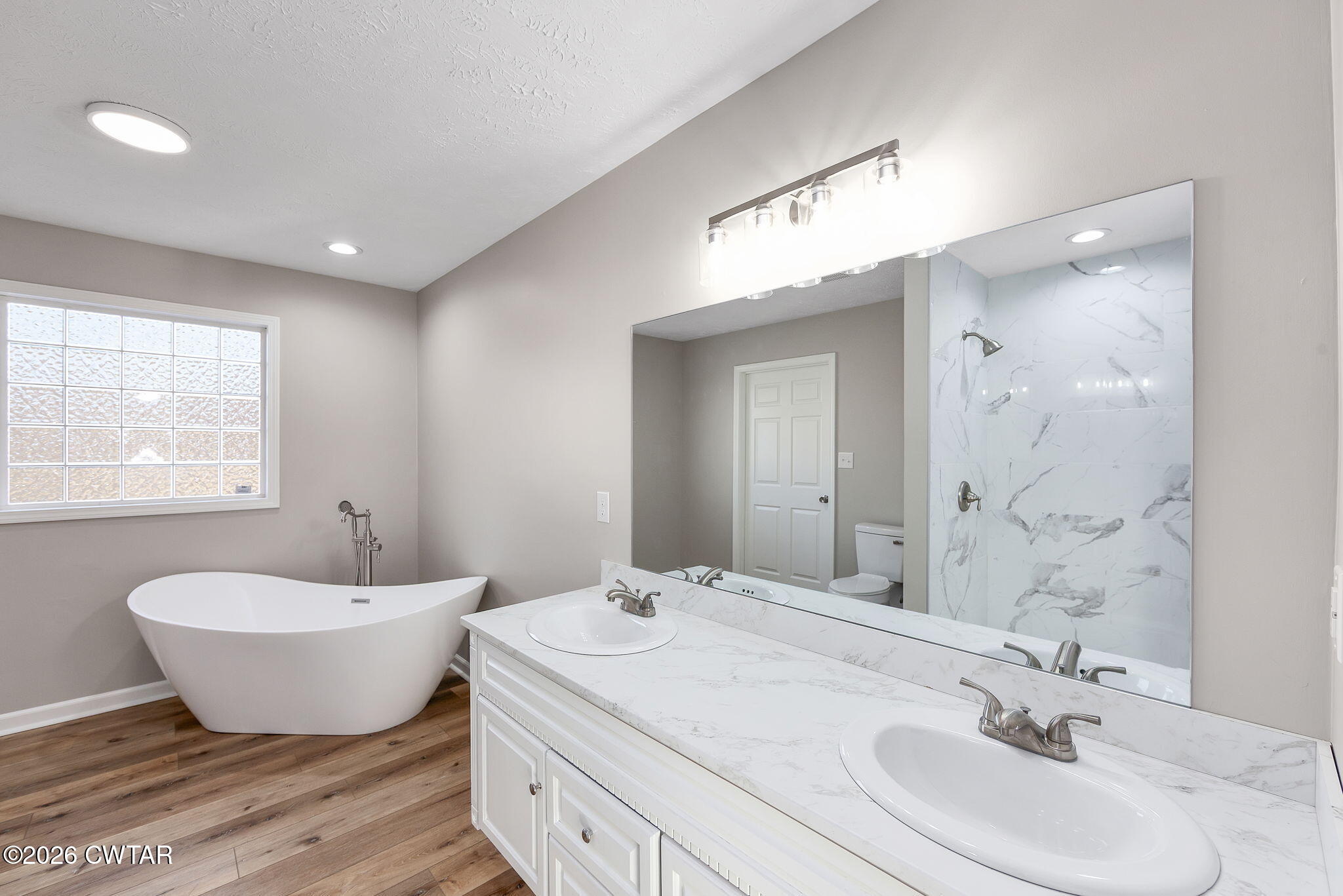 2265 Bond Ferry Road Brownsville, TN 38012 - Photo 8 of 26 a spacious bathroom with a double vanity sink a mirror and a bathtub