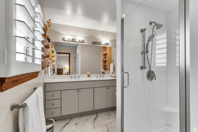 2863 Fallentine Road Sandy, UT 84093 - Photo 31 of 48 Bathroom featuring a dual vanity with a stone countertop, a large mirror, and overhead lighting