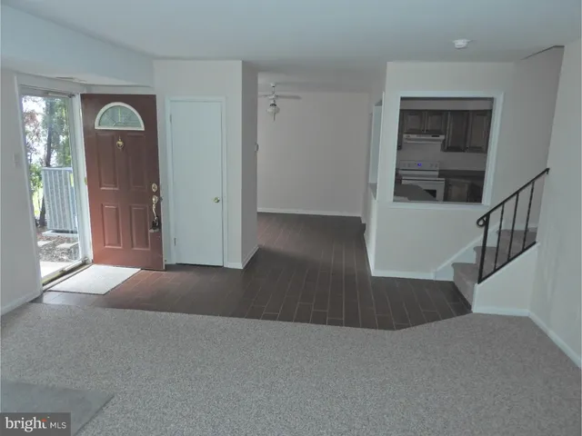 a view of a hallway with wooden floor and windows