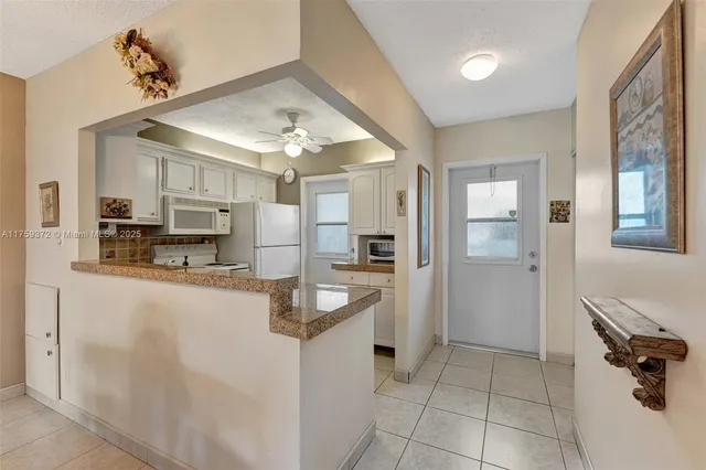 a kitchen with stainless steel appliances kitchen island granite countertop a refrigerator and a sink