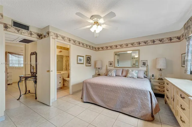 a spacious bedroom with a bed and a chandelier