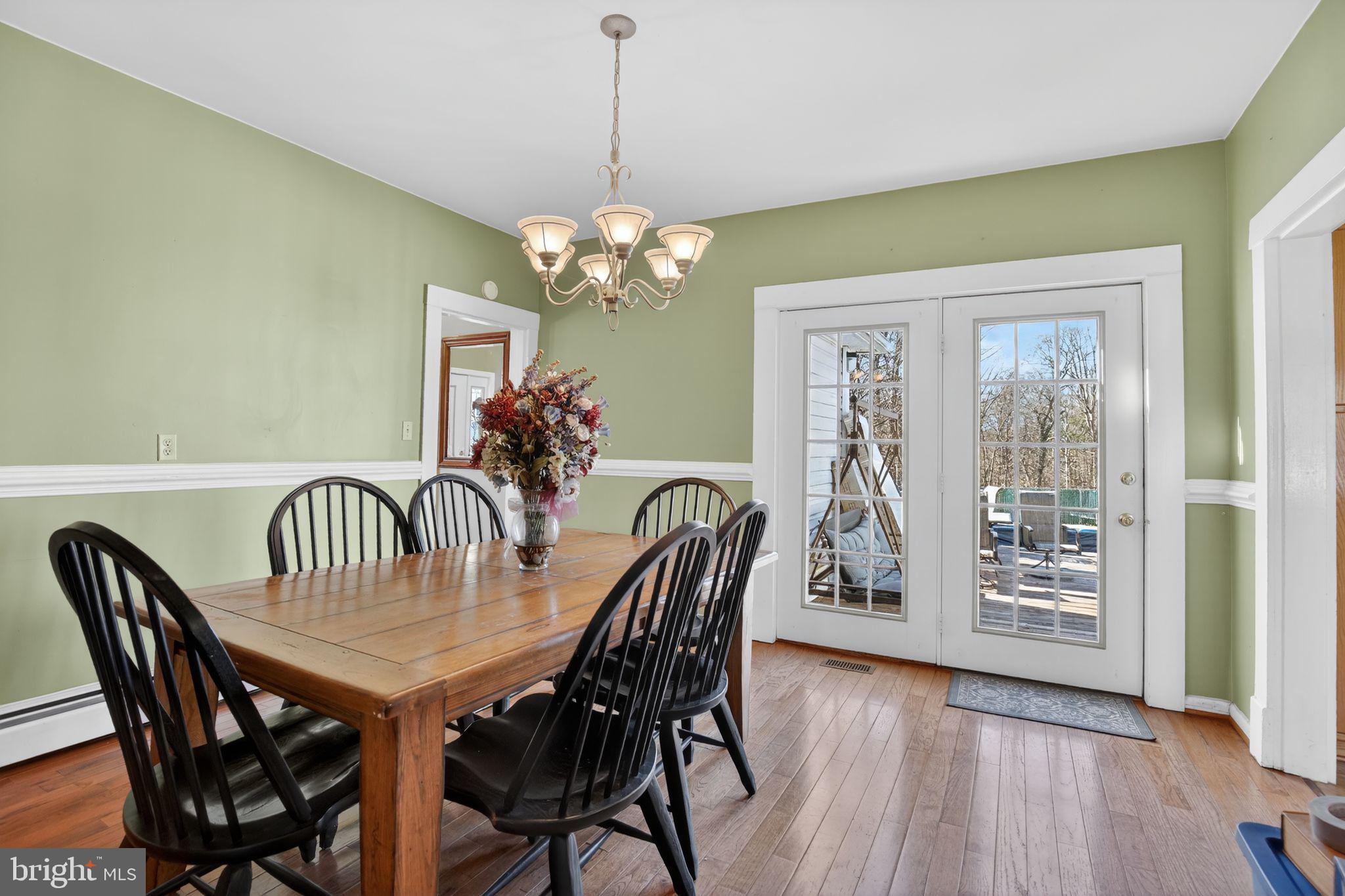26669 Queentree Road Mechanicsville, MD 20659 - Photo 31 of 48 a view of a dining room with furniture wooden floor and chandelier