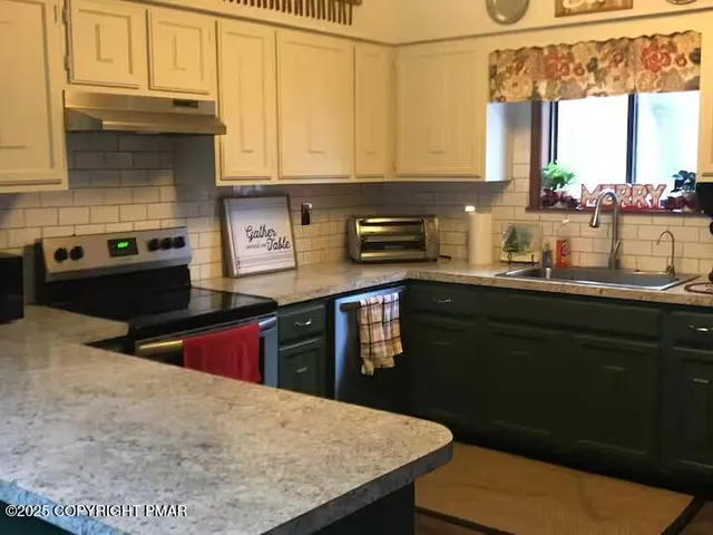 a kitchen with stainless steel appliances granite countertop a sink a stove a refrigerator cabinets and dining table