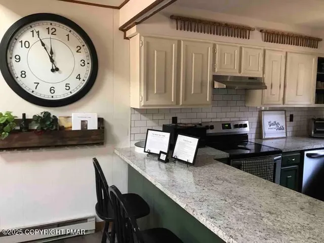 a kitchen with a granite countertop sink stove and cabinets