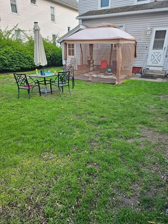 a backyard of a house with plants and tree
