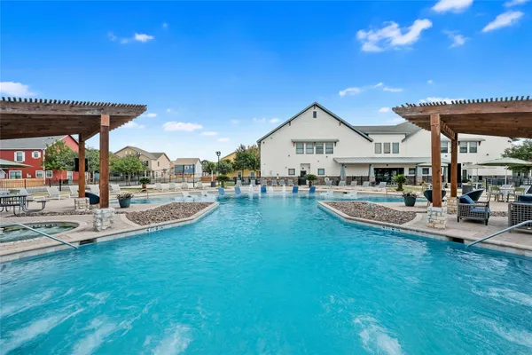 a view of a swimming pool with lawn chairs under an umbrella