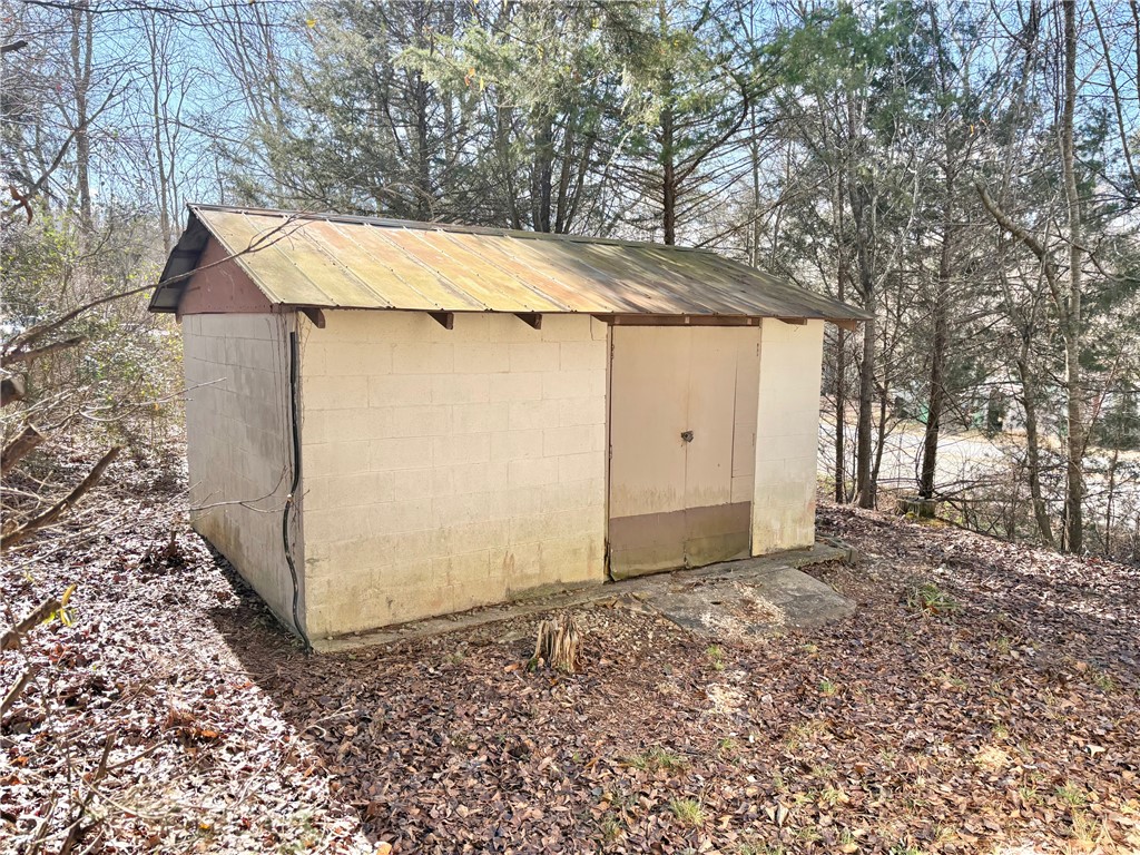 1404 Farrs Bridge Road Easley, SC 29640 - Photo 26 of 27 This outdoor shed offers practical storage solutions amidst a natural, wooded setting.